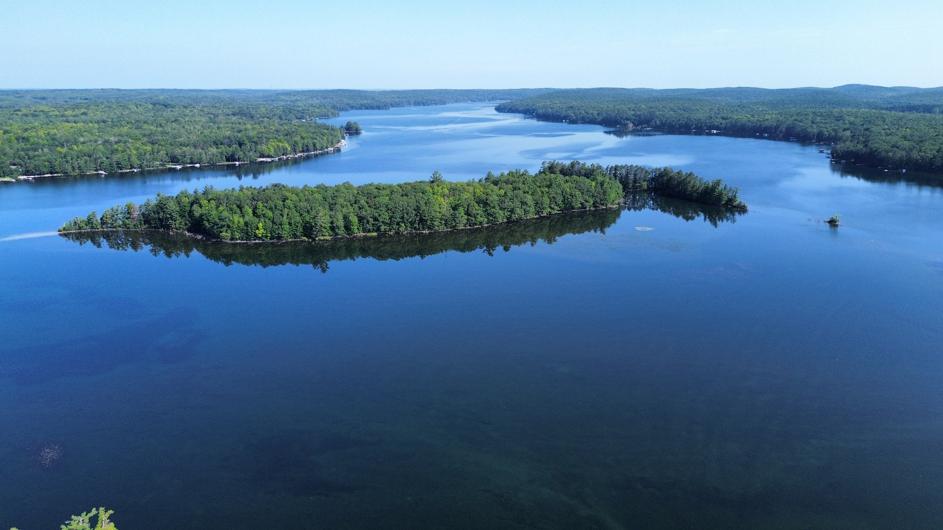 Aerial view of a north-woods lake with forested coves and islands